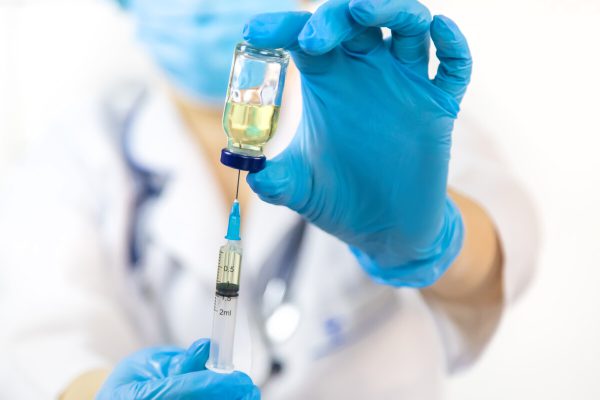 Doctor filling syringe with medication, closeup. Vaccination and immunization. Selective focus. Vaccine.