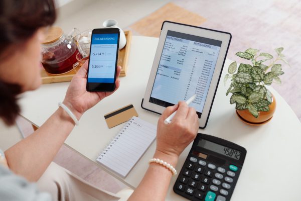 Woman using online banking when checking her brokerage account on tablet compter